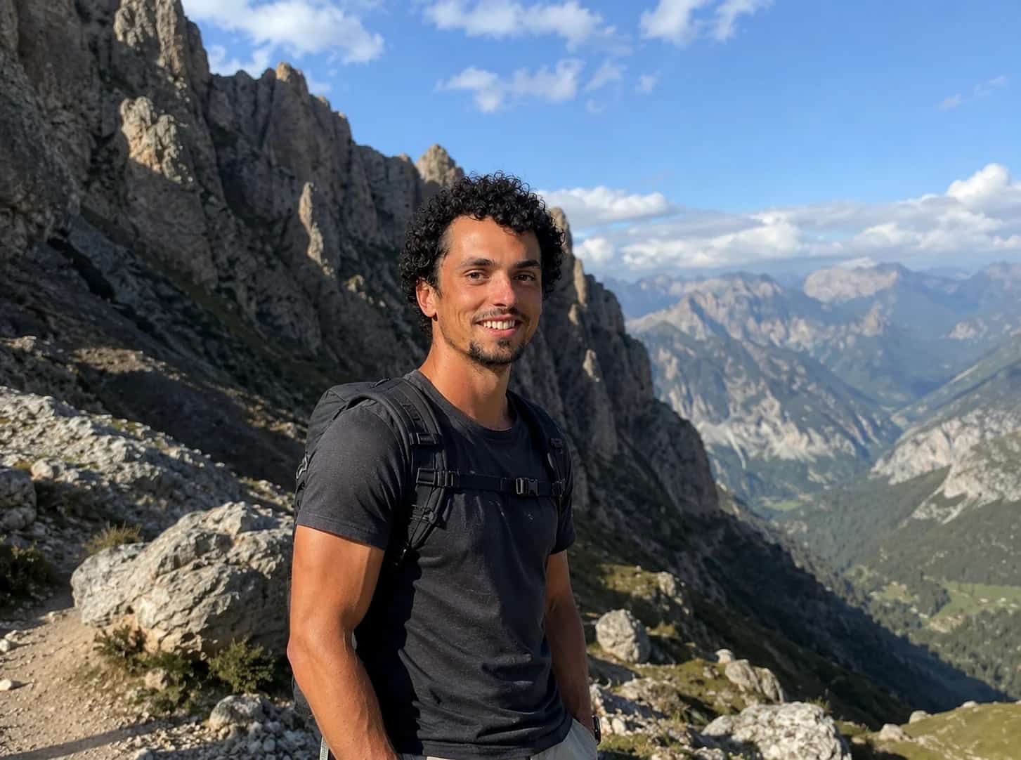 Roberto on a Dolomite ridge in summer, the valley falling away behind him